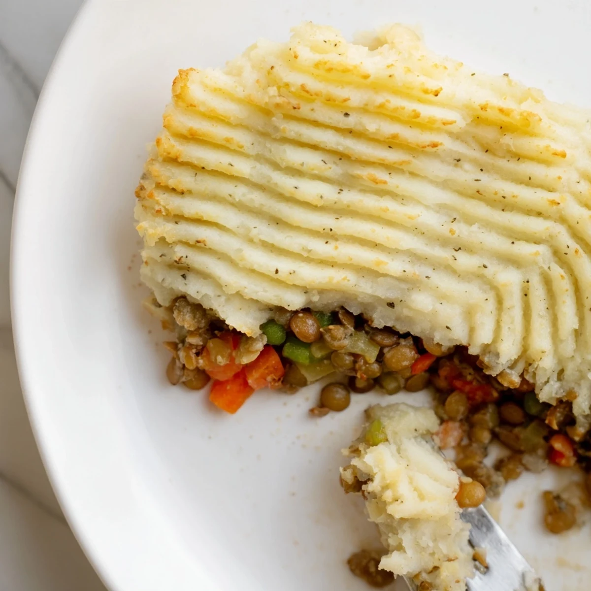 Warm, inviting image of Hearty Lentil Shepherds Pie, showcasing the tender lentils and vegetable filling.