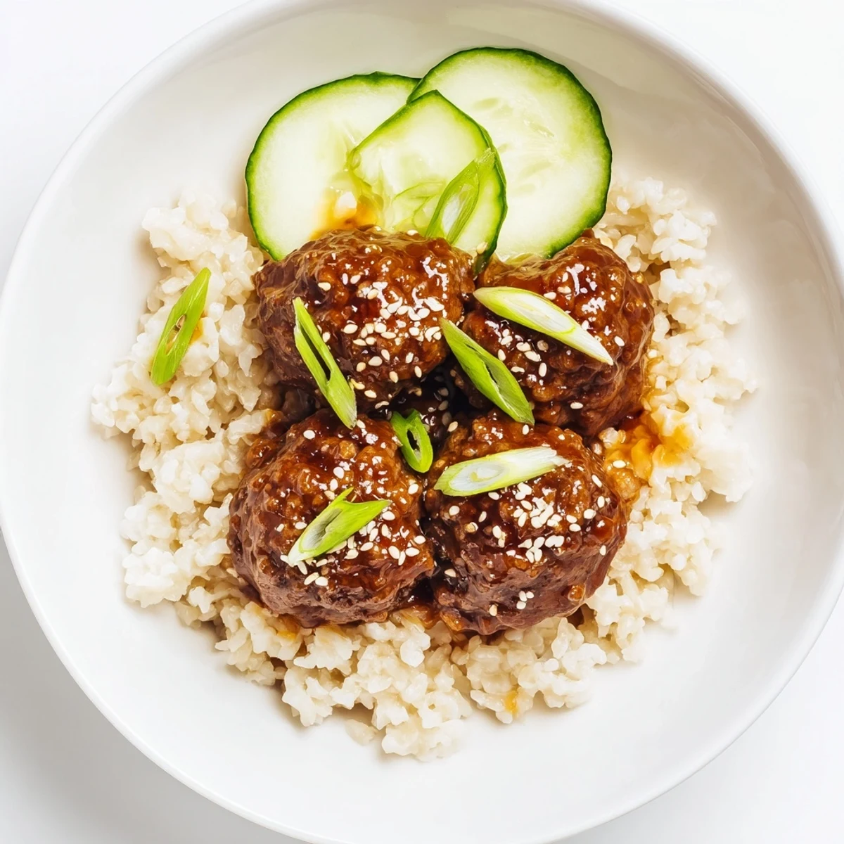 Savory Teriyaki Meatball Bowls bursting with flavor, showcasing glistening meatballs, rice, and crisp cucumber slices.