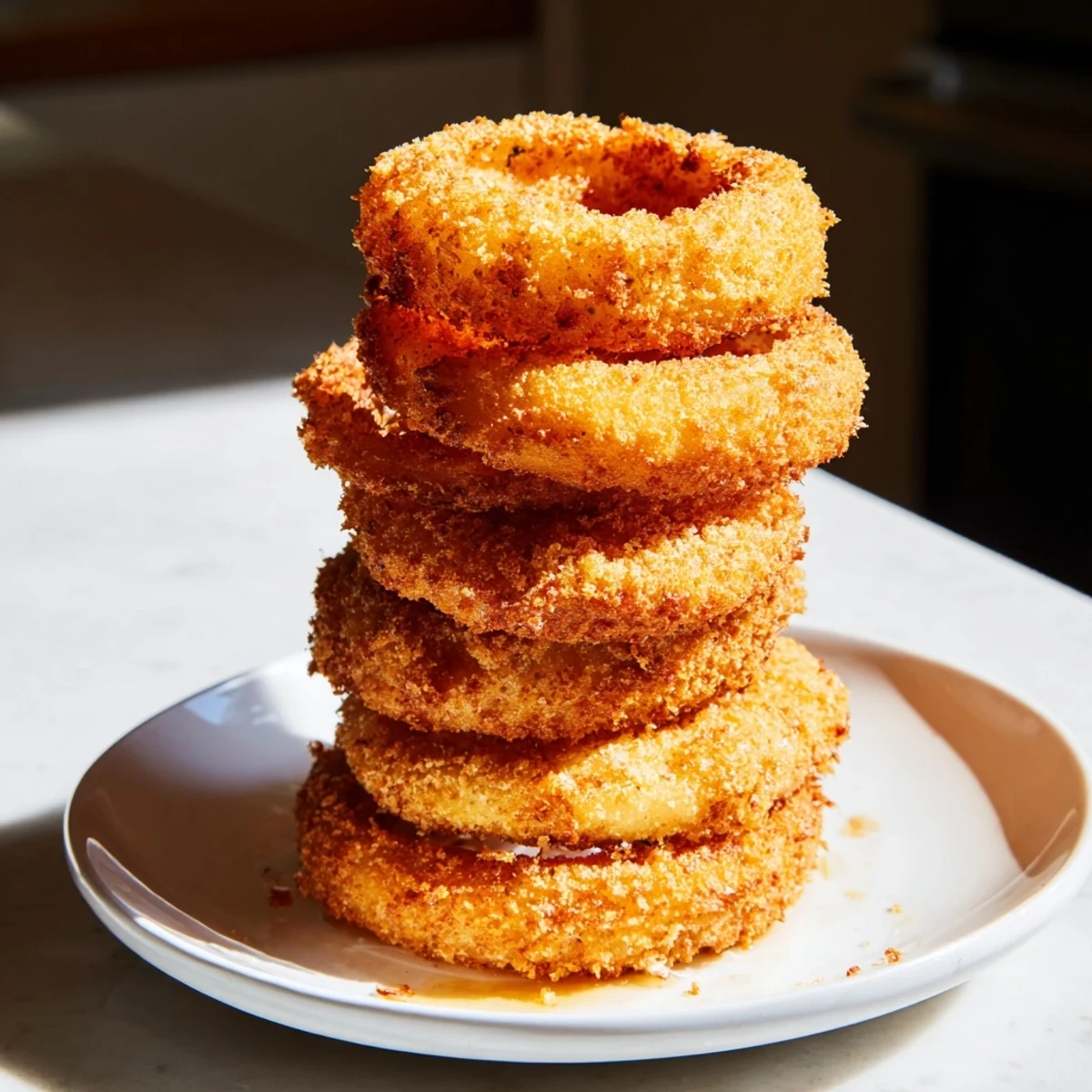 This photo shows a delicious, towering stack of perfectly fried Crispy Onion Rings ready to serve.