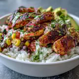 Close-up of a sizzling Cajun Chicken Bowl, highlighting golden-brown chicken and sweet corn ready to be devoured.