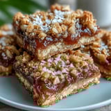 Sliced Guava Jam Bars reveal pink guava jam and macadamia nuts with a serving suggestion.