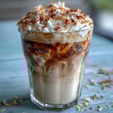 Iced Vanilla Bean Frappuccino with Toasted Coconut Foam, a creamy coffee drink blended with real vanilla bean and topped with a golden coconut foam.