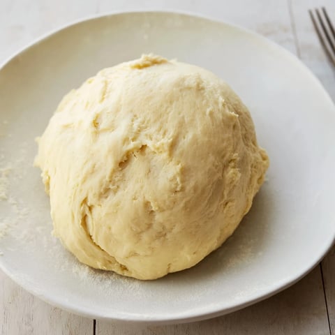 Freshly baked homemade pizza dough, golden and bubbly, perfect for your favorite toppings tonight.