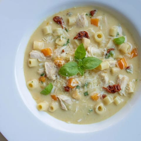 A steaming bowl of comforting Marry Me Chicken Soup, garnished with fresh basil, for a cozy dinner.