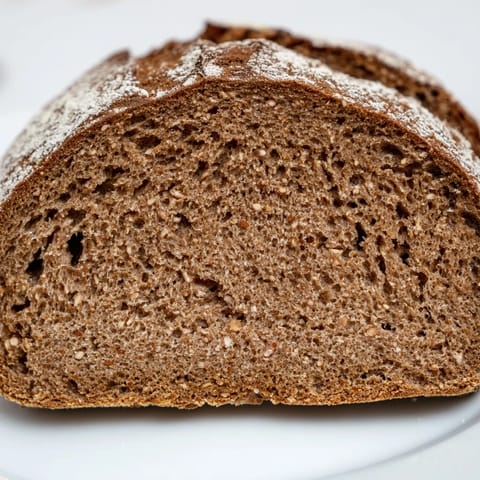 This warm photo of Latvian Rupjmaize bread shows its dense interior, perfect for toasting and enjoying.