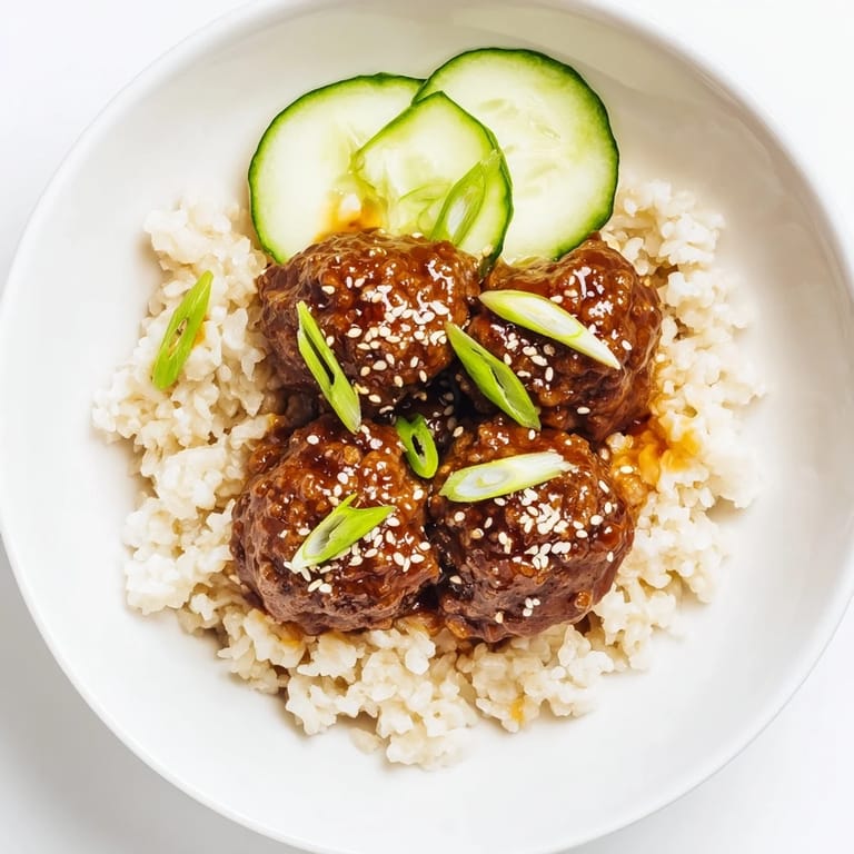Savory Teriyaki Meatball Bowls bursting with flavor, showcasing glistening meatballs, rice, and crisp cucumber slices.
