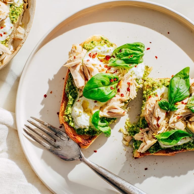 Pesto Chicken Burrata Toast showcases a crunchy sourdough base with vibrant green pesto, sliced chicken, and torn burrata for an Italian-inspired bite.