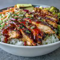 Vibrant BBQ Chicken Bowl with juicy glazed chicken, fluffy rice, and crunchy coleslaw ready to serve.